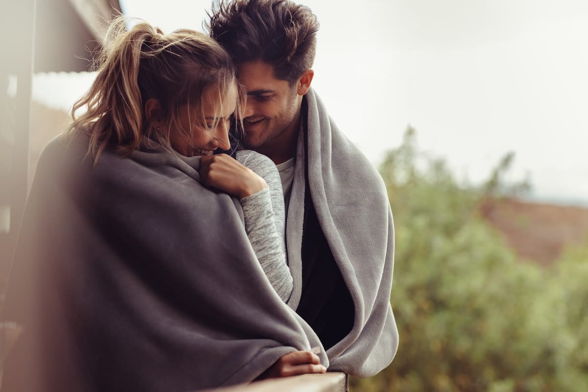 A loving couple, wrapped in a blanket, susceptible to STDs from oral sex.