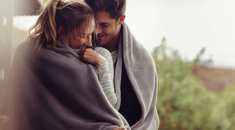 A loving couple, wrapped in a blanket, susceptible to STDs from oral sex.