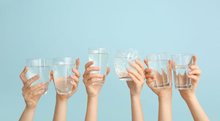 Female hands with glasses of water