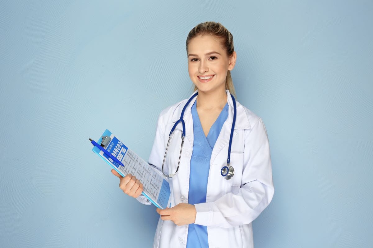 Female doctor with clipboard on color background