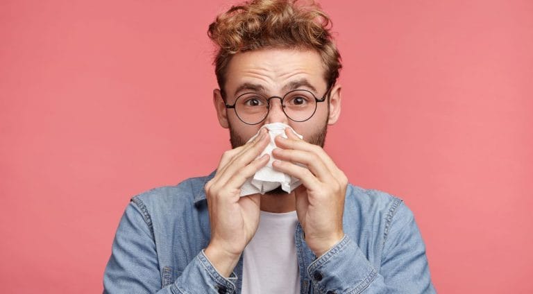 bearded man has running nose, rubs nose with handkerchief