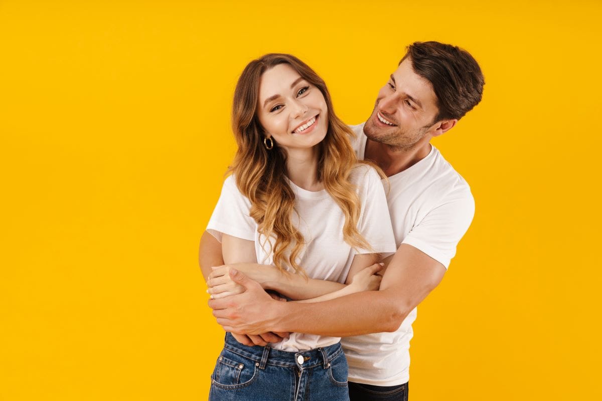 loving couple man and woman in basic t-shirts smiling and hugging together