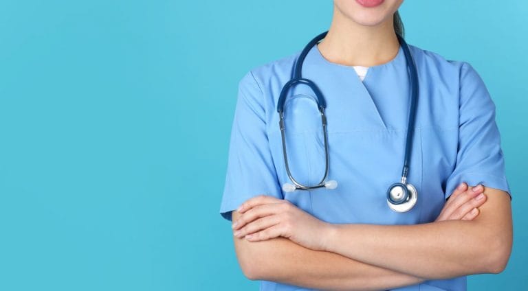 Young medical student in uniform on color background, closeup