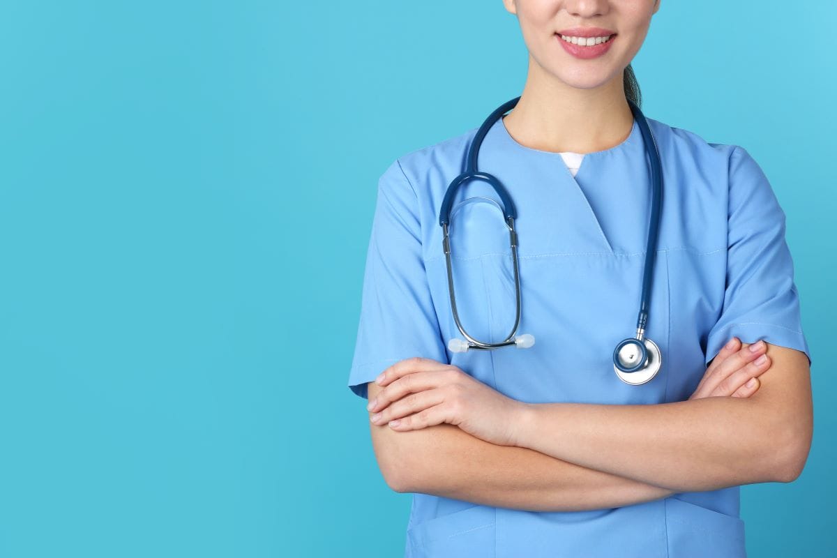 Young medical student in uniform on color background, closeup